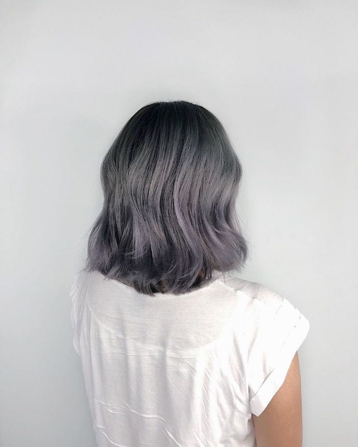 Chic wavy bob with lavender-gray highlights on black hair